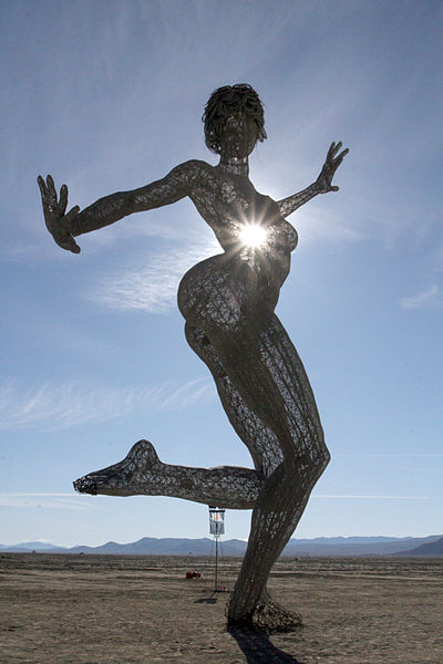 A woman dancing with the sun shining behind her